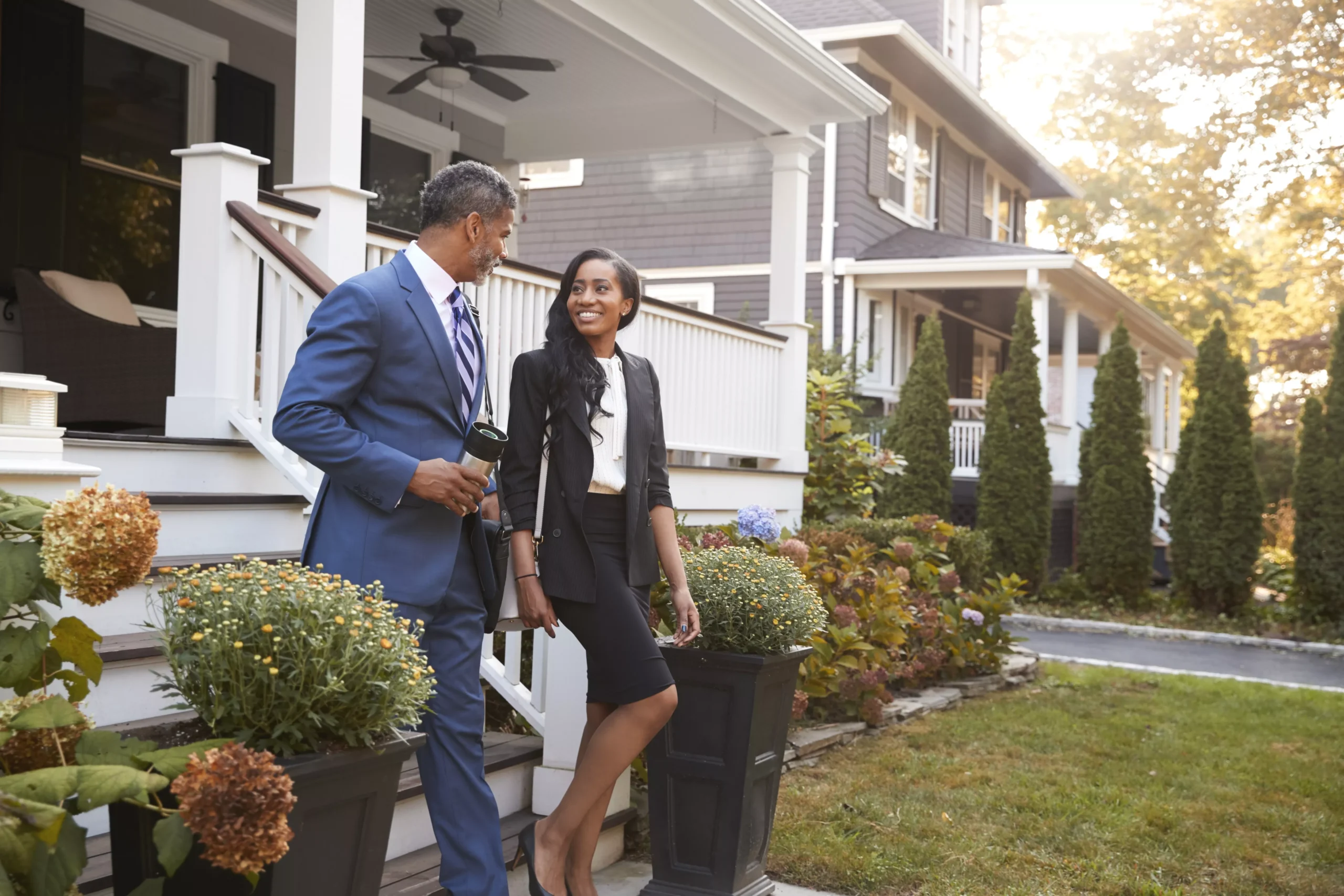 business-couple-leaving-suburban-house-for-commute