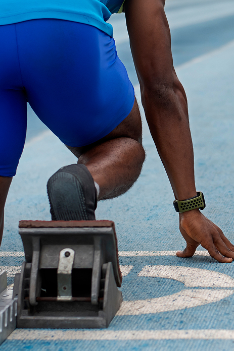 Athlete in starting position on a track with foot on a starting block
