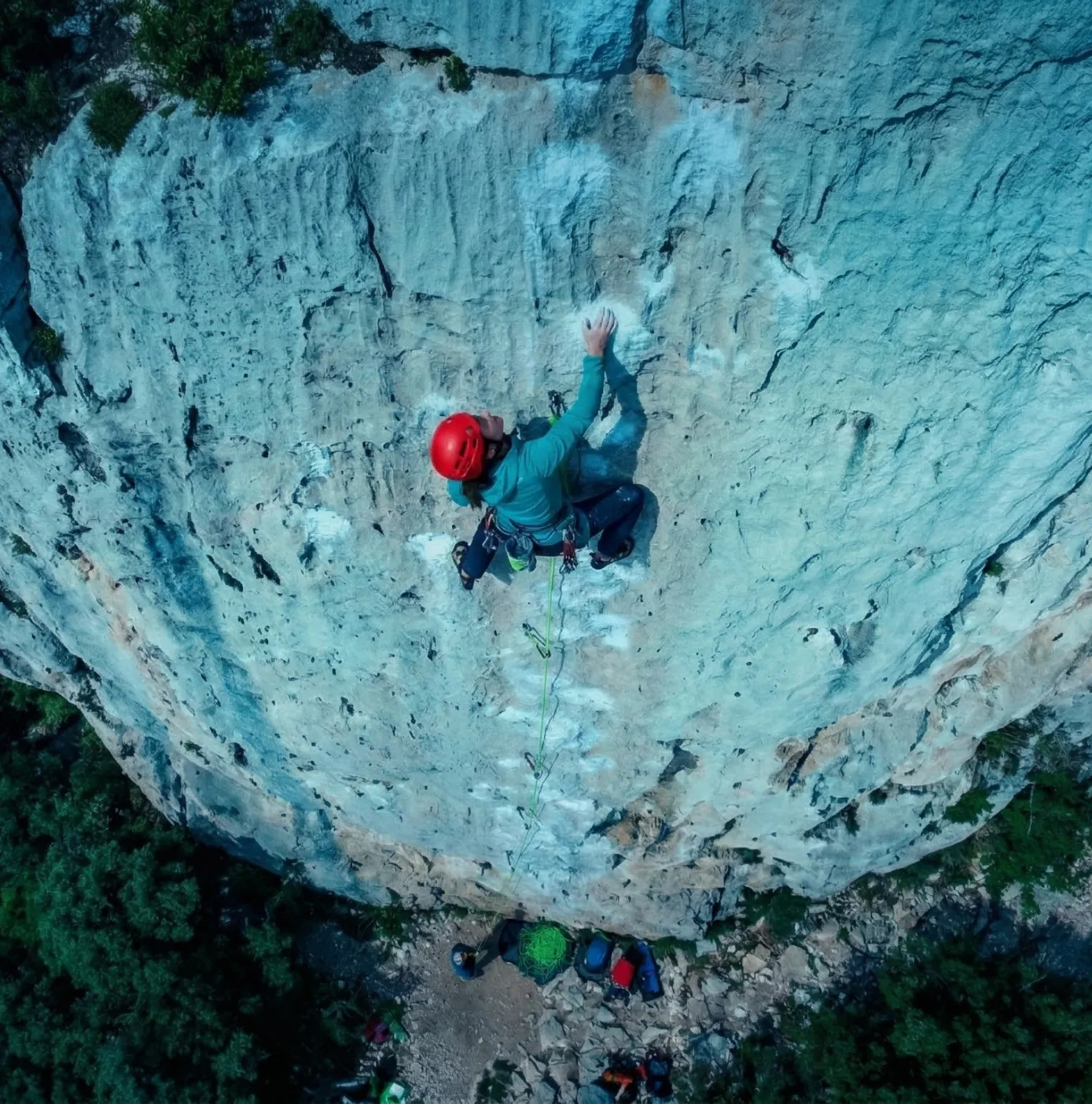 Aerial view of a rock climber scaling a steep cliff face