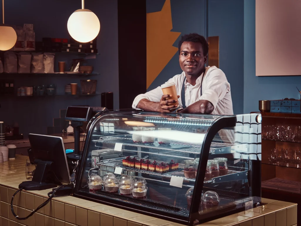 african-barista-relaxing-after-workday-with-coffee