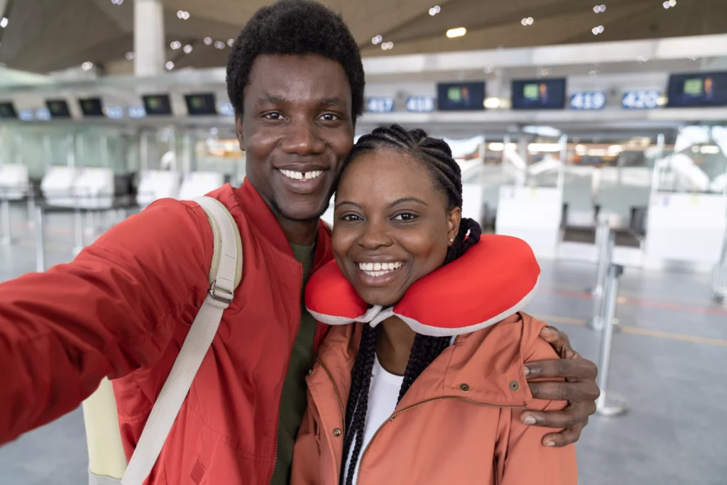 happy-black-millennial-couple-taking-selfie-at-airport