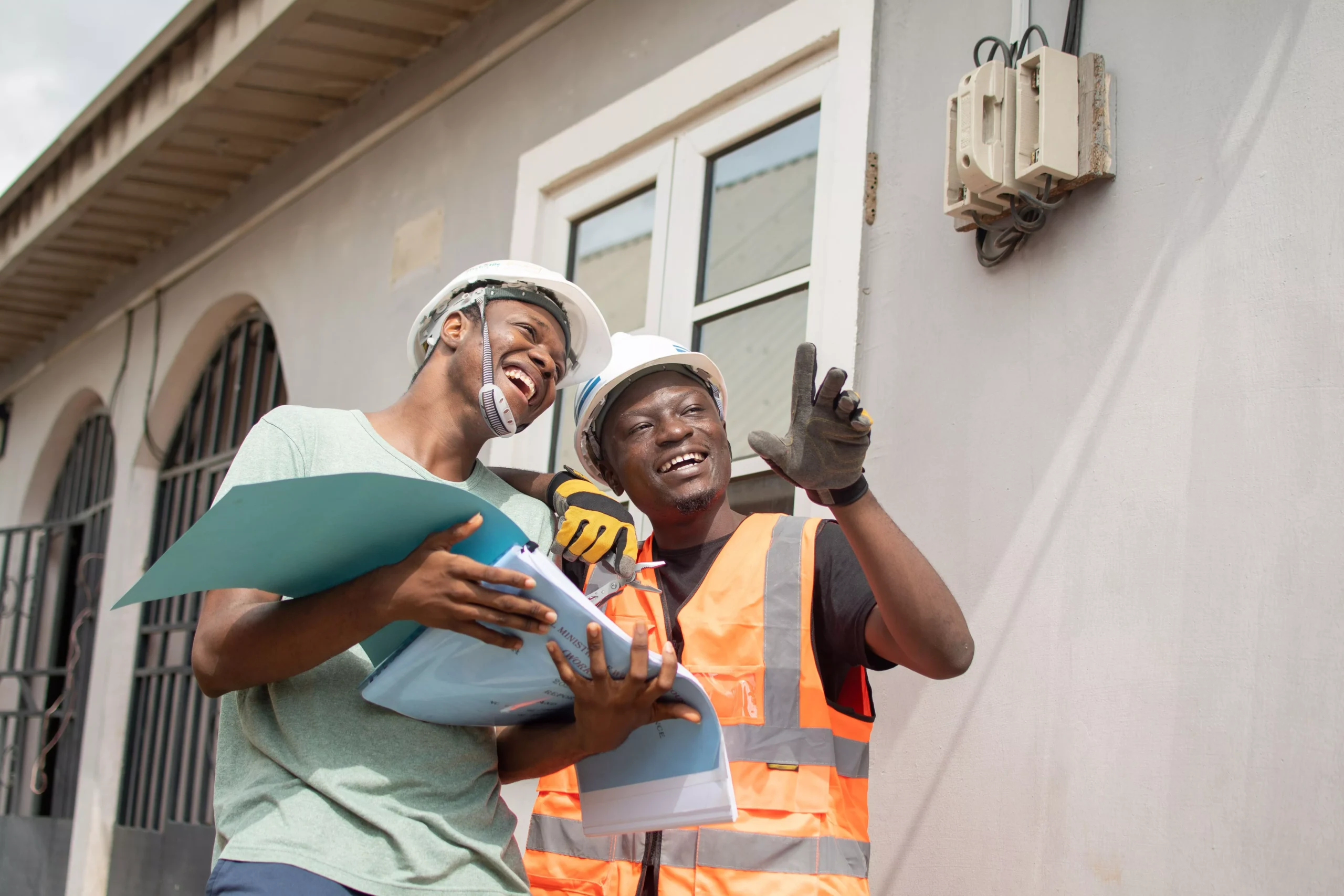 two-people-in-safety-vests-and-hard-hats-looking-a