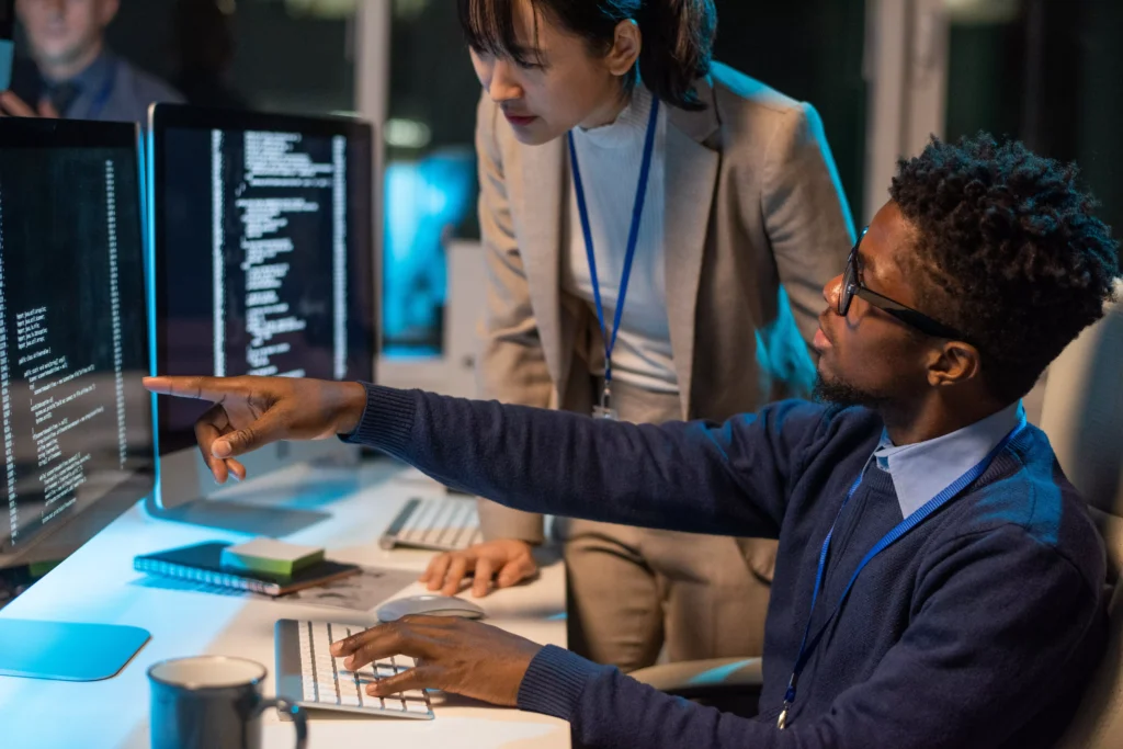 two-young-intercultural-colleagues-discussing-code