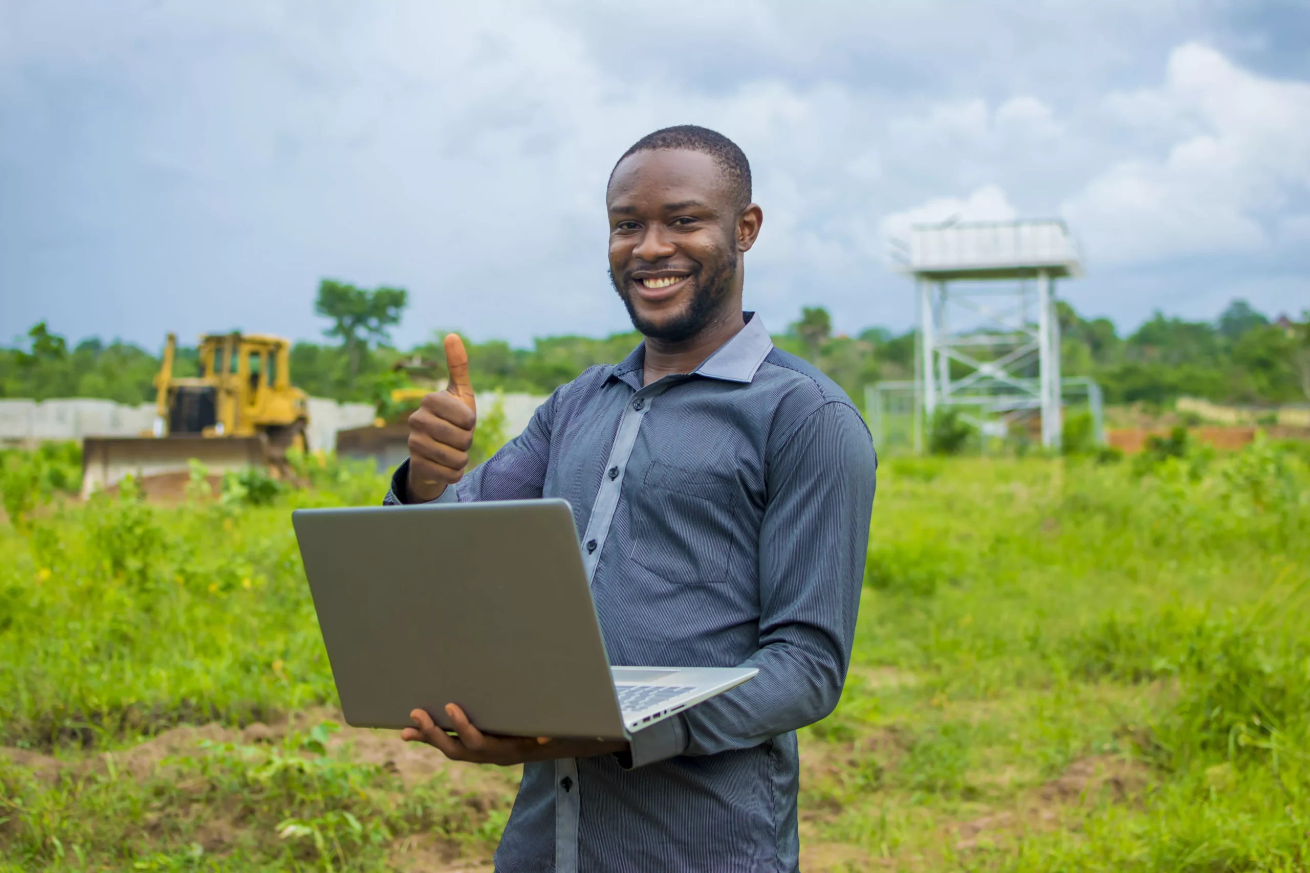 young-african-male-standing-outside-with-a-laptop