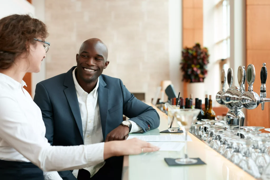 young-businessman-sitting-with-woman-at-bar-counte
